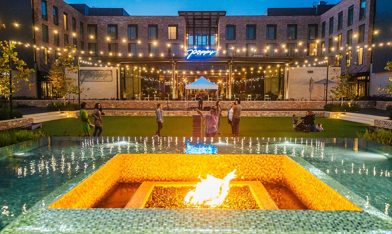 People by a firepit at the century square mixed-use destination in College Station, Texas