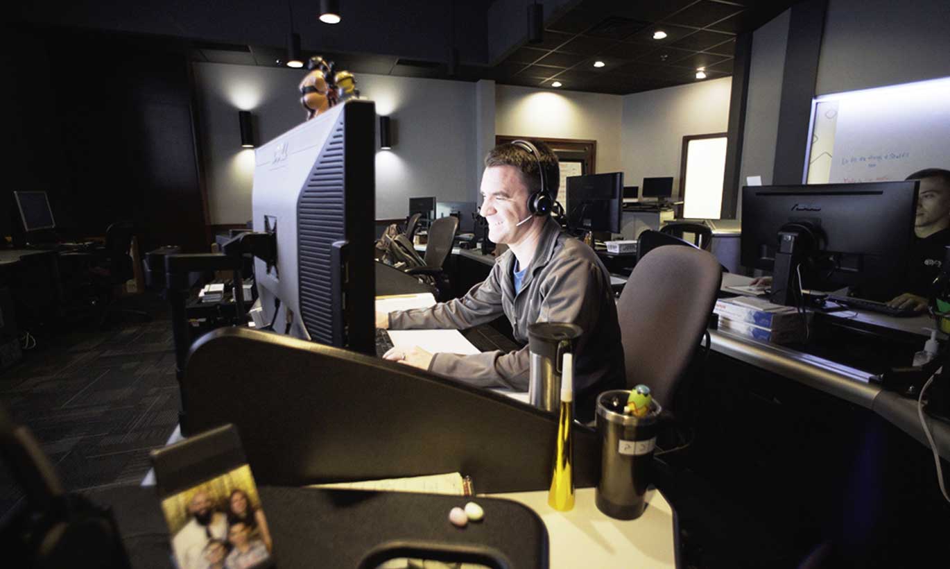 An employee works at a desk with a headset at PDI in Temple, Texas.