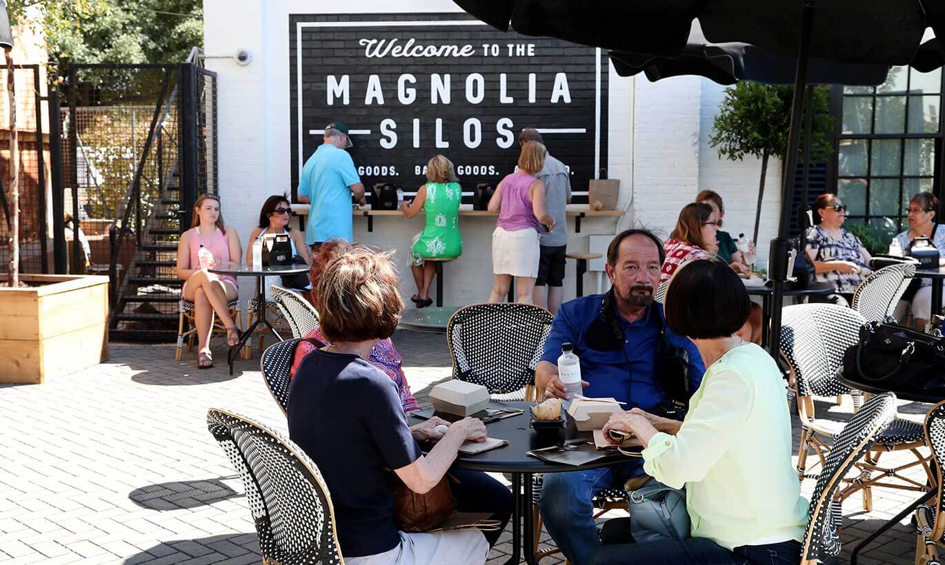People sit outside to eat at tables at Magnolia Market in Waco, Texas.